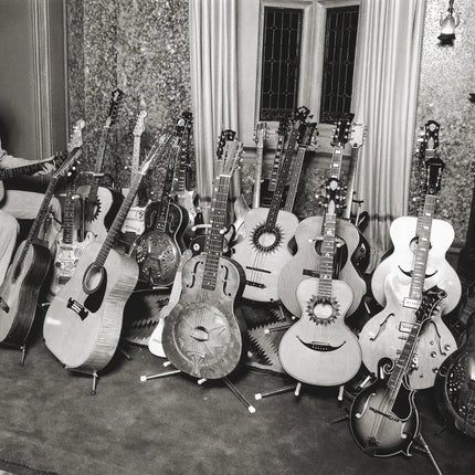 George Harrison of The Beatles with his guitar collection at home, Henley-on-Thames 1979, photographed by Brian Aris